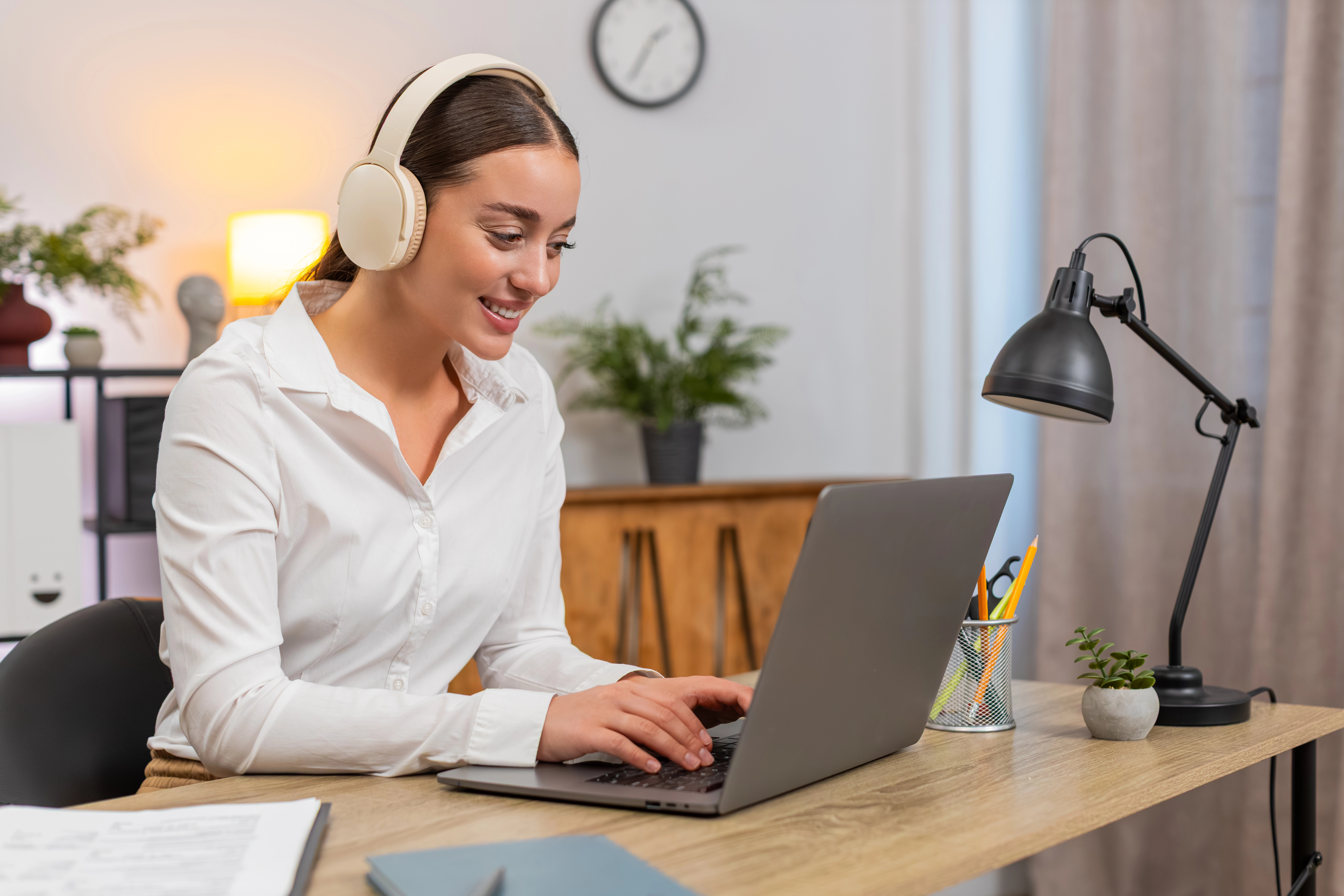 Professional working on laptop with headphones in a modern workspace