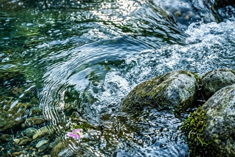 Closeup of a flowing water current moving over river rocks